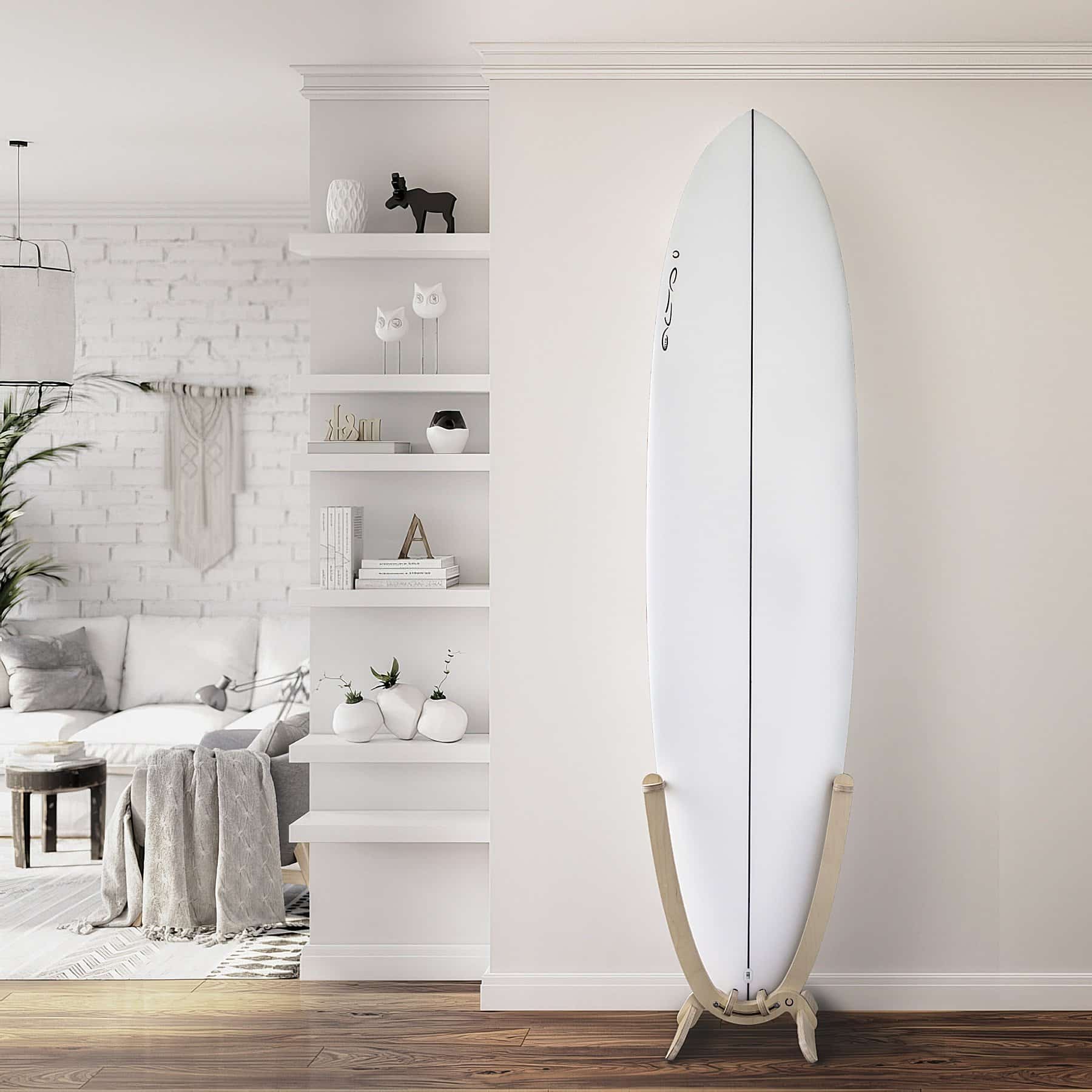 An all white Surfboard with a GLYD O decal on its nose, is mounted in a GLYD O surfboard rack. The rack with board is standing on a wooden floor against a flat white wall. The room opens up to the left of the rack and board, there are inset shelves on the corner of the flat white wall with ornaments, books and small plants. Around the corner there is a white brick wall a couch, small coffee table, Lamp, wall hanging, plant and hanging light.
The surfboard rack and surfboard really pop in this picture and the image gives you an idea of the feeling and vibe the GLYD O surfboard rack brings to a room.
The Surfboard Rack is a Beautiful birchwood curved single surfboard rack in the shape of the tail of a surfboard, with hooks to hold the rails and tail and two slightly curved feet connected perpendicular to the upright curved arms. Image is taken from the front in relations to the vertical surfboard rack.